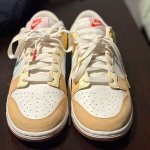 Nike Dunk Low Sneakers in White and Tan Yellow, Blue Swoosh.